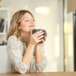 Portrait of a woman breathing and holding a coffee mug at home